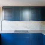 Espace ouvert lumineux, cuisine sur-mesure en retrait, sols pierre claire, maçonnerie et réseaux anticipés — réalisation DOMTY Construction à Saint-Tropez.