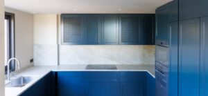 Espace ouvert lumineux, cuisine sur-mesure en retrait, sols pierre claire, maçonnerie et réseaux anticipés — réalisation DOMTY Construction à Saint-Tropez.