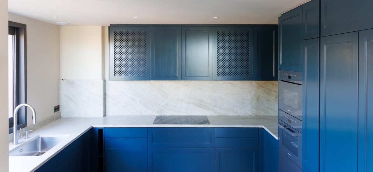 Espace ouvert lumineux, cuisine sur-mesure en retrait, sols pierre claire, maçonnerie et réseaux anticipés — réalisation DOMTY Construction à Saint-Tropez.